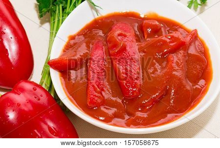 Lecho with peppers and herbs in the white plate