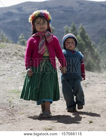 Portrait of a Native Peruvian girl and her little brother dressed in colourful traditional handmade outfit. October 21 2012 - Patachancha Cuzco Peru