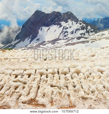 Snowcat track in melting snow. End of winter in Zugspitze arena most famous ski resort in alps on Germany Austria border. 