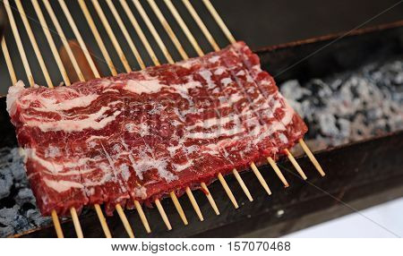 Red Raw Meat While Cooking On The Brazier In A Street Stall