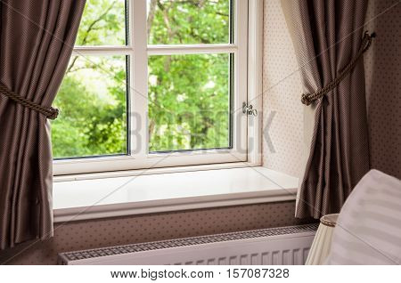 Window with curtains view of summer backyard