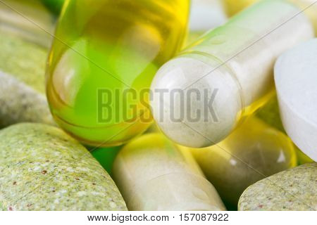 Mixed natural food supplement pills omega 3 multivitamin and glucosamine capsules macro image