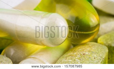 Mixed natural food supplement pills omega 3 multivitamin and glucosamine capsules macro image