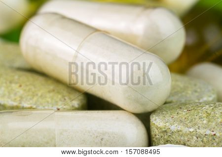 Mixed natural food supplement pills multivitamin and glucosamine capsules macro image