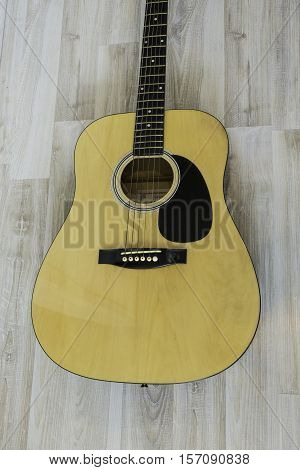 Acoustic guitar on a light wooden background