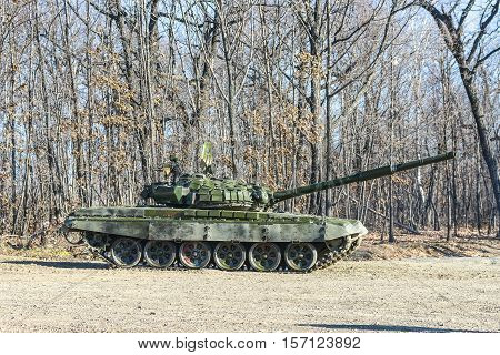Russian tank rides on a forest road