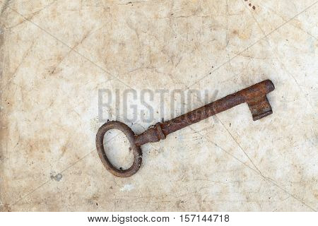 Detail of the rusty key on old parchment