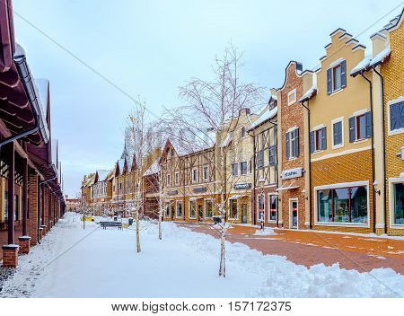 KIEV UKRAINE - NOVEMBER 11 2016: The brick stepped gable houses of Dutch Revival style shopping city look great in white cover of snow on November 11 in Kiev.