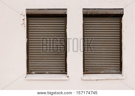 Wall with two closed using roller-blind windows. Office in bad block.