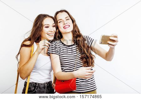 two best friends teenage girls together having fun, posing emotional on white background, besties happy smiling, making selfie, lifestyle people concept close up