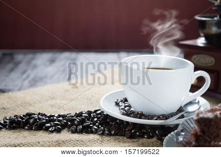 Coffee Cup And Beans On A Rustic Background. Coffee Espresso And A Piece Of Cake With A Curl. Cup Of