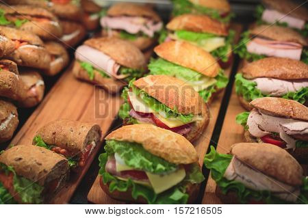 Beautifully decorated catering banquet table with different toasted triangle sandwiches on a plate on corporate christmas birthday party event or wedding celebration