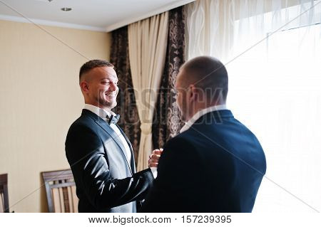 Two Handsome Male Friends Meet And Shaking Hands Each Other. Groomsman Or Best Man Greeting Groom At