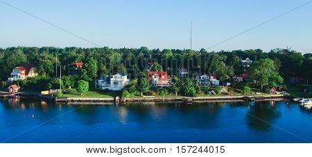 Beautiful super wide-angle aerial view of Stockholm archipelago skerries and suburbs with classic sweden scandinavian designed cottage houses from massive ferryboat