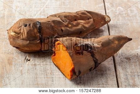Oven baked sweet potatoes on vintage wood.