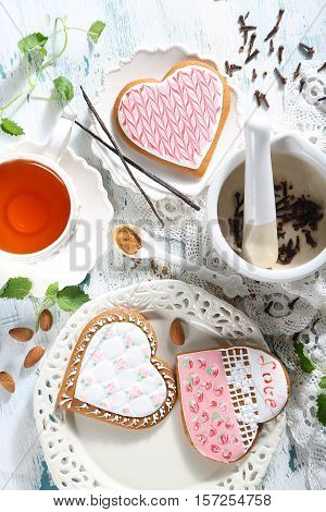 Gingerbreads in the form of hearts and tea are served on a table