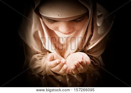 Young muslim woman praying in mosque. raising his hands ending the prayer.
