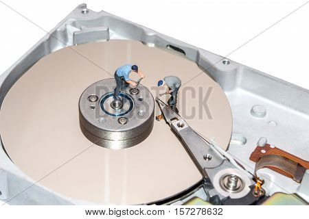 Miniature people repairing the hard drive. A broken computer equipment. Figures of people. The team of employees.