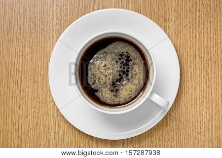 Coffee cup on a wood surface, top view