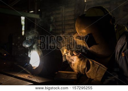 Worker welding repair spare part by SMAW process
