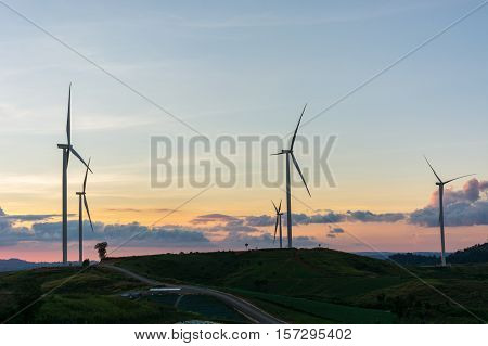 Silhouette wind generators turbines on sunset summer landscape in Thailand