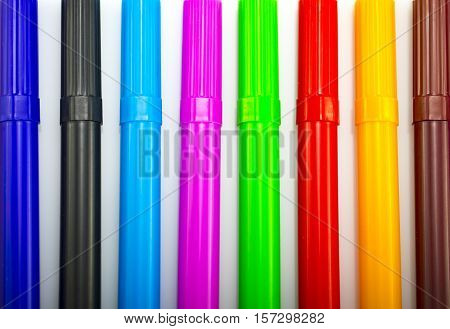 Colorful markers in a row isolated on a white background