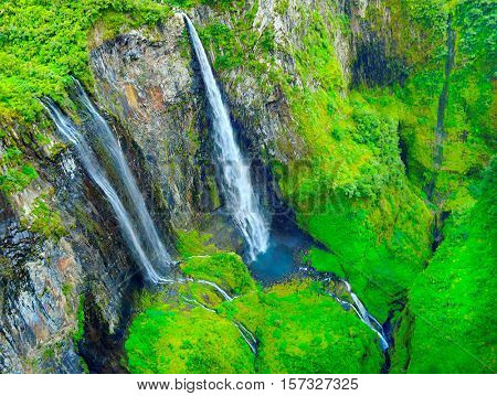 Aerial view to waterfall in tropical rainforest. Cirque Salazie is amazing scenery in center Reunion Island, overseas department of France.