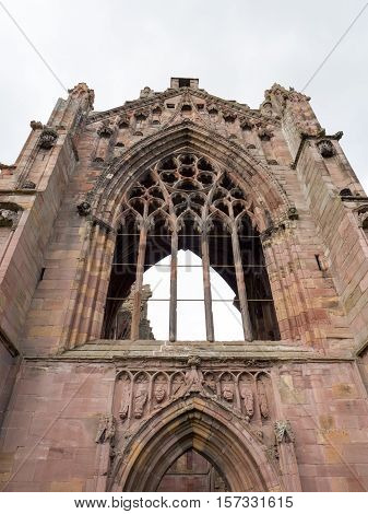 The ruins of pink colored Melrose Abbey in the Scottisch Borders region in Scotland