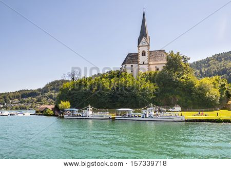 Maria Worth Austria - August 14 2016: Vintage tourist boats at the church of Maria Worth waiting for passengers. Saints Primus and Felician Church in the background is popular pilgrimage site.