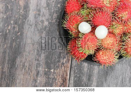 rambutan sweet fruit fresh in plate on wood background :Select focus with shallow depth of field.