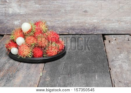 rambutan sweet fruit fresh in plate on wood background :Select focus with shallow depth of field.