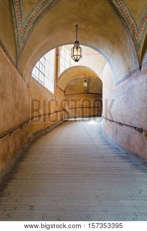 An arched tunnel with wooden floor in an old Cesky krumlov castle with sunlight from the window Czech