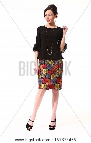 woman with updo hair style in cocktail party blac blouse patchwork skirt high heel shoes stand full body length isolated on white
