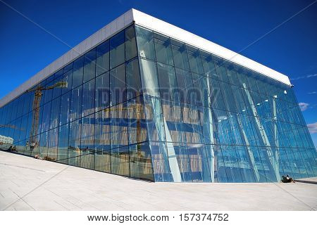 OSLO NORWAY - AUGUST 17 2016: Tourist on the Oslo Opera House which is home of Norwegian National Opera and Ballet and National Opera Theatre in Oslo Norway on August 172016.