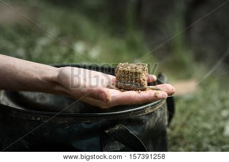 fishing a feeder in hand against the bucket for bait