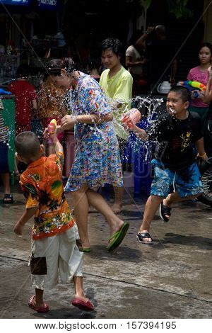 Bangkok, Thailand - April 13, 2008 : 
During Songkran the Thai New Year's festival. Teenagers watering passers-by on the street.