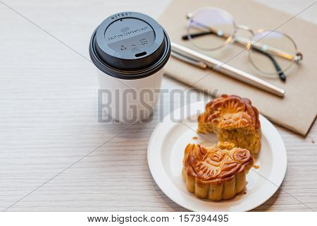 A Chiness Moon Cake With A Hot Disposable Coffee Cup