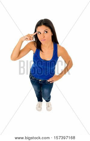 young attractive hispanic woman in casual top and jeans pointing her head thinking and wondering confused in doubt isolated on white background