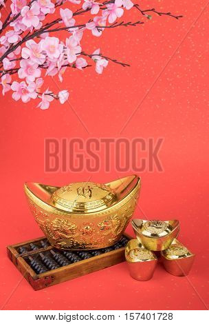 Chinese gold ingot and abacus with Chinese calligraphy mean symbols of wealth and prosperity.