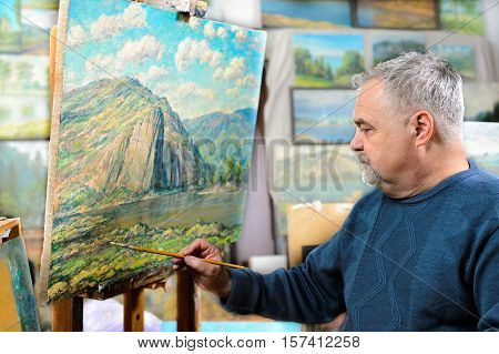 Artist Paints Oil Painting With A Brush And Palette