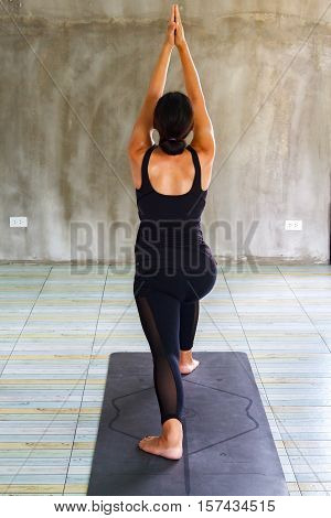 Young woman practicing yoga in a urban background