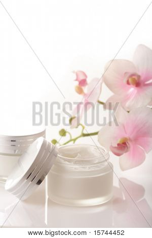 hrnec hydratační krém na obličej a krásné květy orchidejí