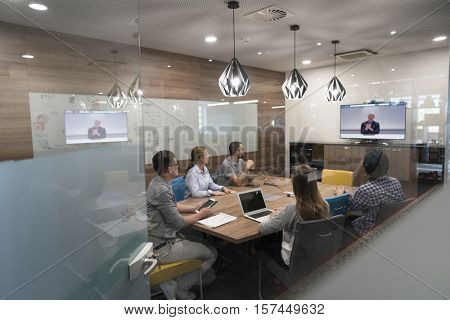 start up business people group attending videoconference call with senior investitior at modern office