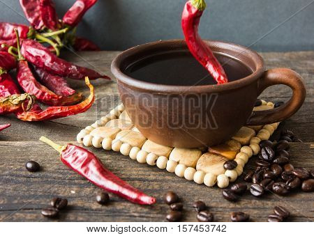 black coffee with pepper spicy. wooden background.