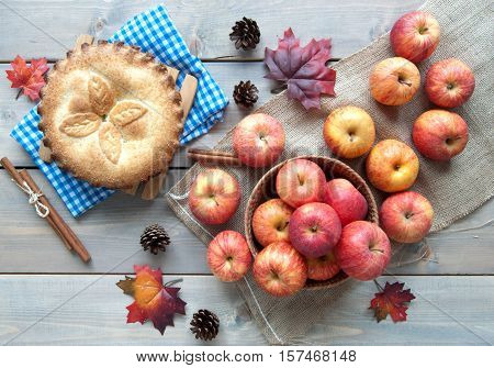 Apple pie with ingredients cinammon sticks and autumn leaves