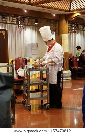 BEIJING - FEBRUARY 22: Cutting peking duck on a plate in the original Quanjude restaurant at the Qianmen street in Beijing, China, February 22, 2016.