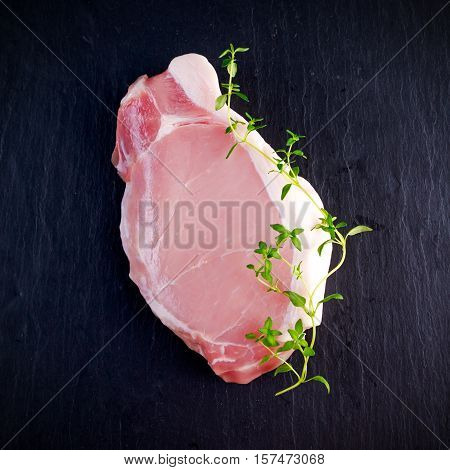 Top view raw pork loin steak on stone background.
