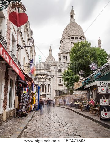 PARIS FRANCE - 28TH JULY 2016: A view along streets in Montmartre Paris during the day. The Sacre-Coer can be seen in the distance