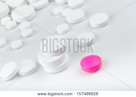 Bunch Of White Tablets. Scattered Pills. Single Pink Pill