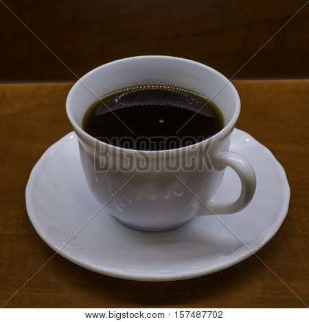 Porcelan cup of coffee on the brown table